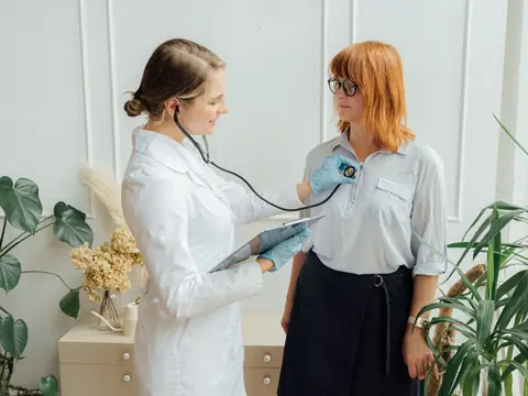 A doctor listening with a stethoscope during a check-up in a calm room